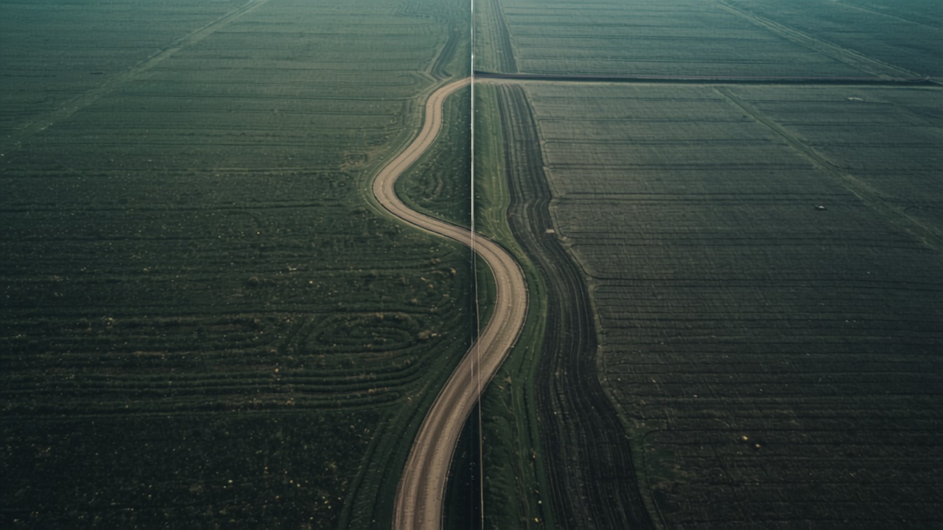 Aerial view of a winding road and boundary line dividing two adjoining agricultural land parcels